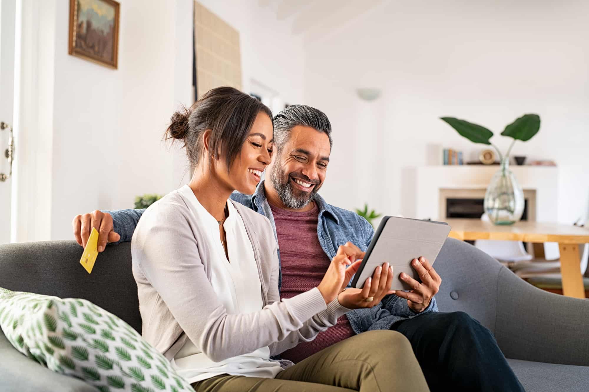 Couple on couch using tablet smart device