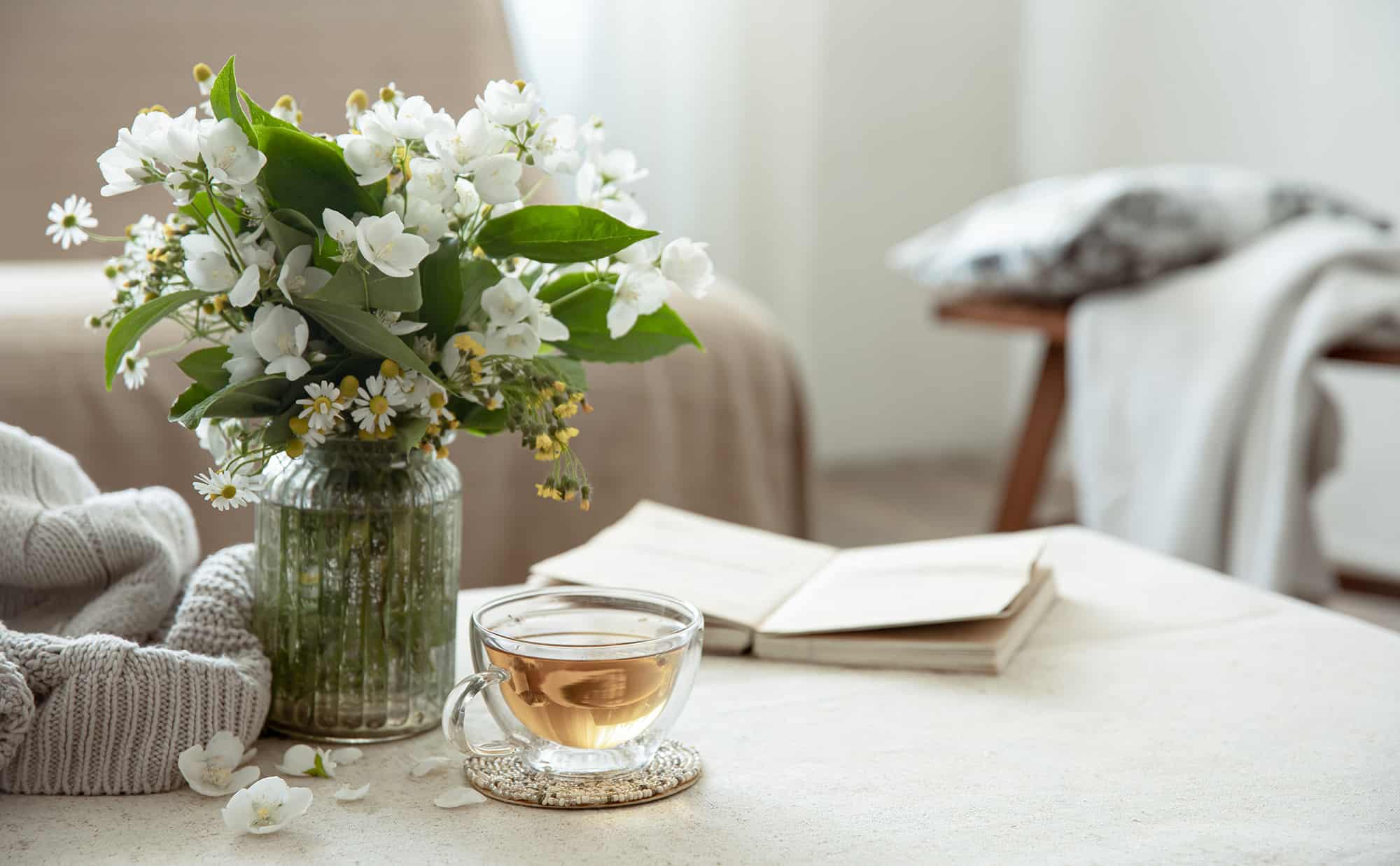 Vase with flowers, cup of tea, and open book