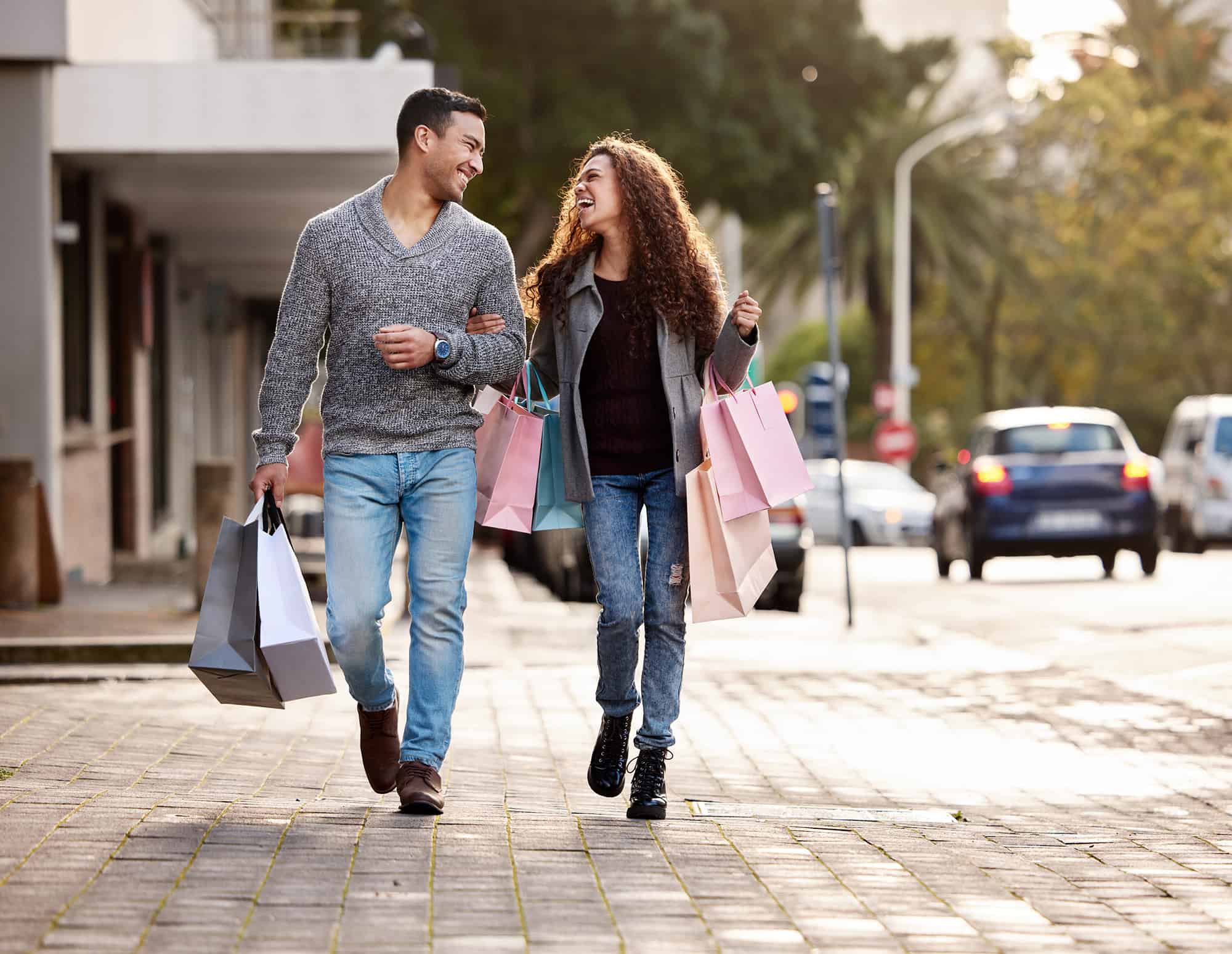 Couple walking outside with shopping bags